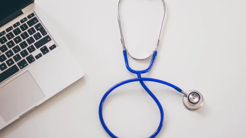 Stetoskop vedľa notebooku na bielom stole, web pre lekára a ambulanciu